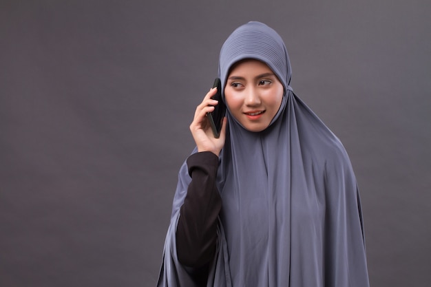 Muslim woman using smartphone call, wireless internet device