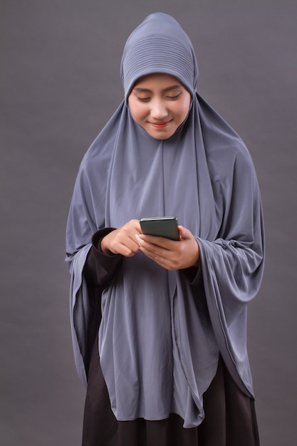 Muslim woman using smartphone, wireless internet device