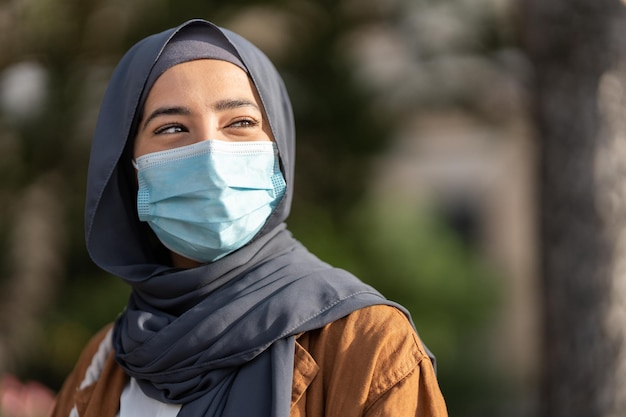 Muslim woman wearing protective facial mask outdoors