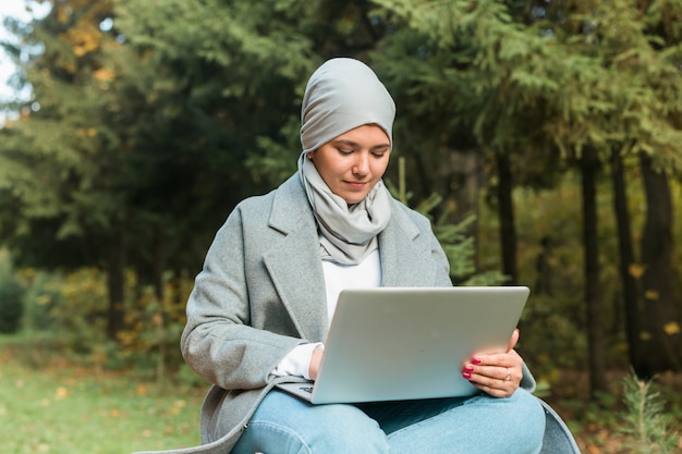 Muslim woman with her laptop in the park