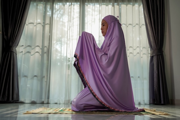 Muslim women praying In the foyer of the house during the coronavirus (COVID-19) outbreak, quarantine concept.