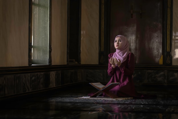 Muslim women wearing purple shirts Doing prayer of Islam.