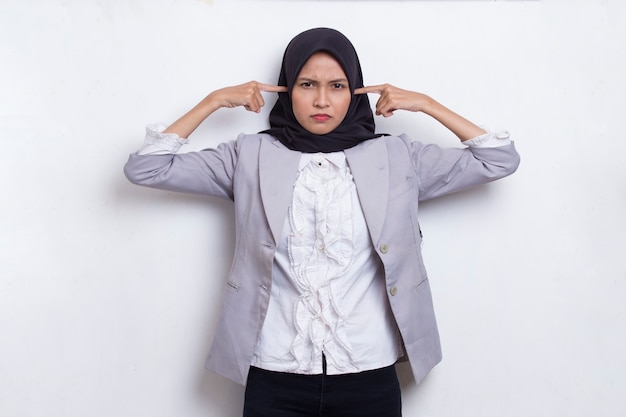 La giovane donna asiatica musulmana si copre le orecchie