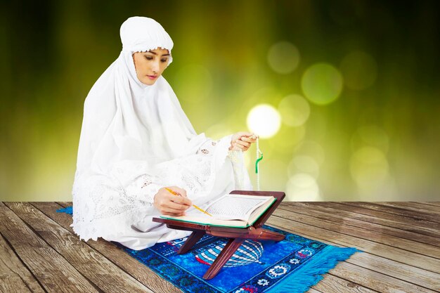 Photo muslim young woman reading quran on wooden floor