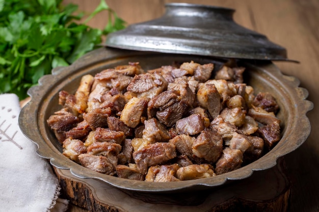 Foto i musulmani sacrificio tradizionale vacanza cibo agnello turco carne arrosto in pentola di rame sul piano del tavolo turco kavurma nome turco kurban kavurma