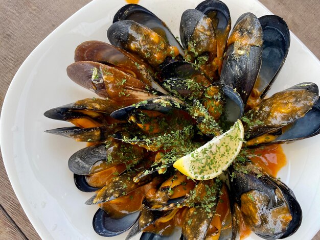 Mussels in the bowl lemon tasty seafood dish Plate with mussels Mussel shells lie on the plate