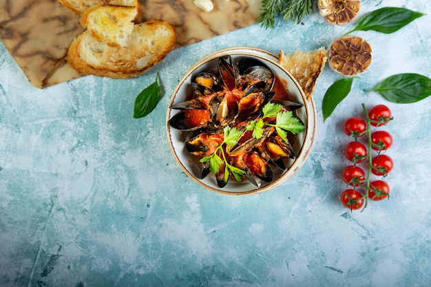 Mussels in a bowl served with tomatoes