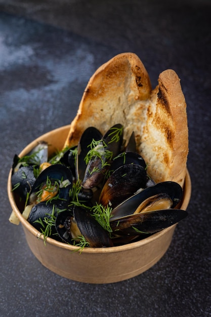 mussels in a cardboard disposable plate with lemon and parsley