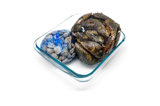 Mussels and clams in two net bags on glass bowl