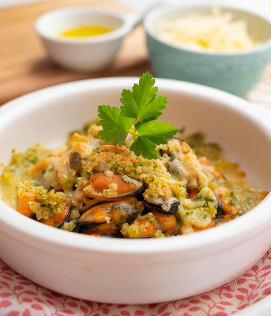 Mussels gratin Gratin seafood dish with bread and parsley