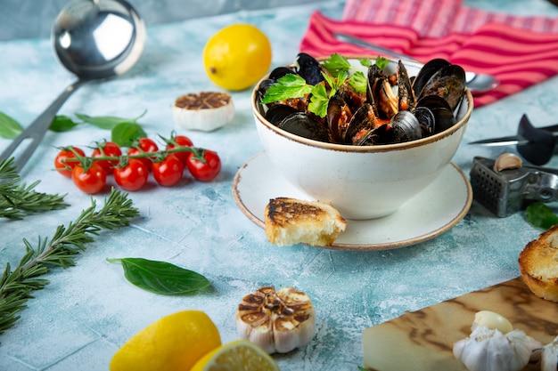 Mussels in Plate served with tomatos, toast and lemon and garlic