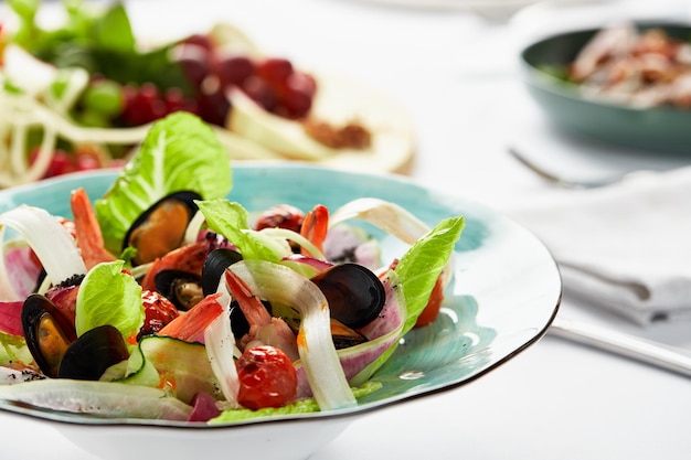 Mussels vongole in a plate with salad mussels cooked in white wine sauce on a party table with white scart salad from the chef of seafood mussels and rum leaves and lola rosa