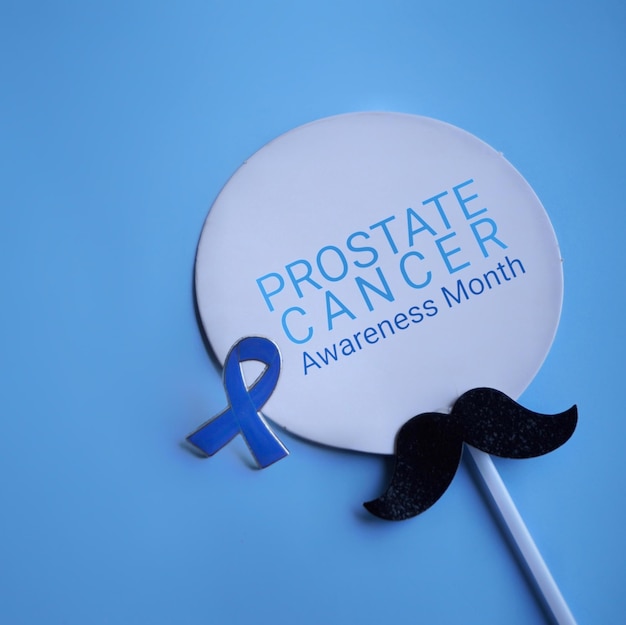 Mustache and blue ribbon with text PROSTATE CANCER AWARENESS MONTH Medical and healthcare concept