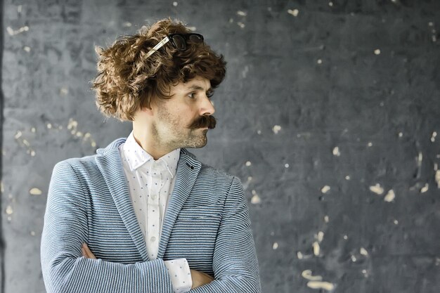 mustachioed man in a classic suit and vintage glasses, curly hipster portrait, long hair