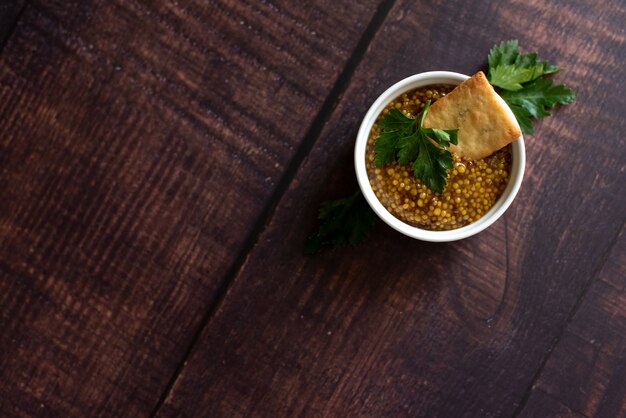 Mustard in the assortment: Dijon mustard, burning Russian mustard and dry grains in bowls 