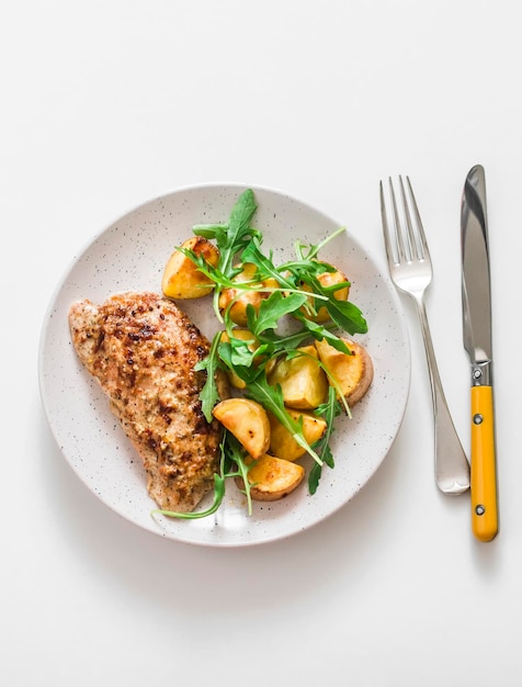 Mustard greek yogurt marinade baked turkey and new potatoes arugula salad on a light background top view