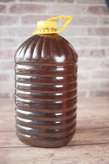 Mustard oil in a plastic jar on table