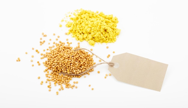 Mustard seeds and powder on white background