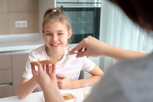 Mutter macht ihre Tochter Sandwich zum Frühstück