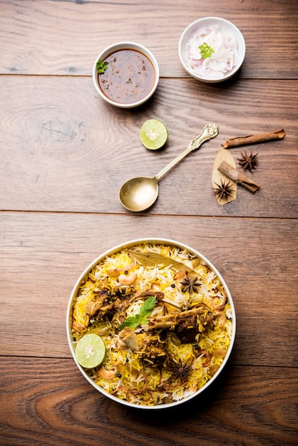 Mutton or lamb biriyani with basmati rice, served in a bowl over moody background