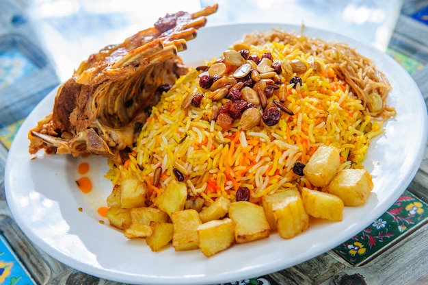 Mutton Lamb kacchi biryani with chili and life on white plate background