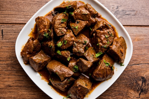 Photo mutton liver fry or kaleji masala, popular non vegetarian recipe from india and pakistan. served dry or with curry in a bowl, karahi or plate