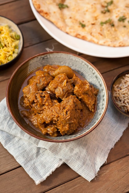 Баранина масала, индийская еда, чеснок наан, миски и тарелки с индийской едой, вид сверху