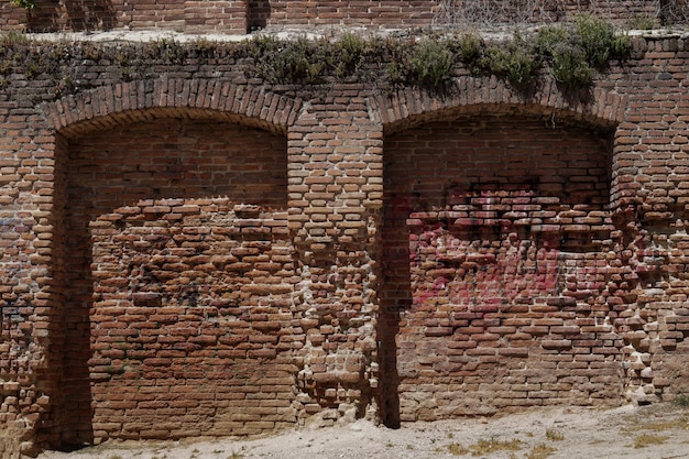 Muur met bogen en planten gemaakt van antieke rode baksteen