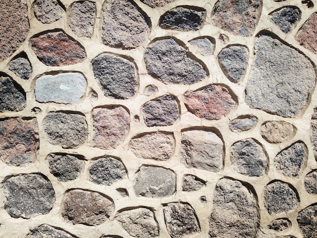 muur van een gebouw dat bestaat uit stenen van verschillende maten en kleuren