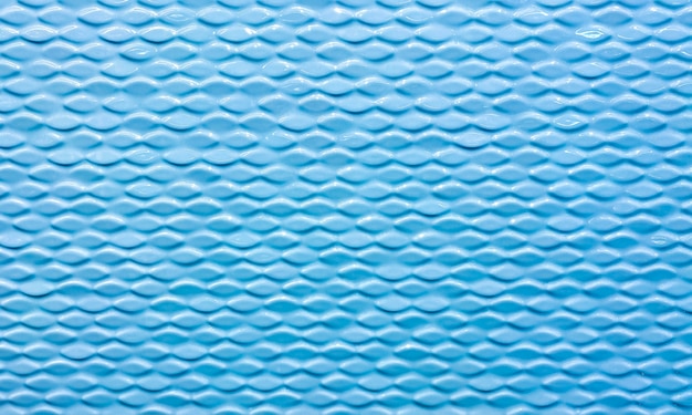 Muur van keramische tegels met getextureerde golven. Blauwe kleur tegels. Achtergrond, textuur