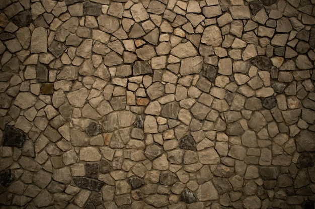 Muur van ruwe steen in donkere kleuren