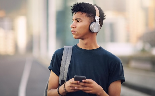 Muziek is leven Bijgesneden opname van een knappe jonge man die wakker wordt op straat en naar muziek luistert via zijn mobiel