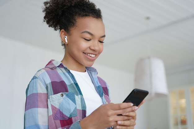 Muziek luisteren in airpods Tienermeisje geniet van favoriete nummer in draadloze oortelefoons