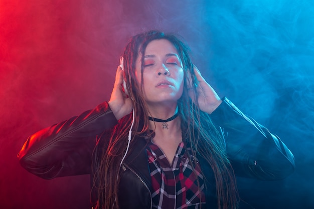 Muziek, meloman en mensenconcept - Een gelukkige vrouw met dreadlock die naar muziek luistert en ervan geniet