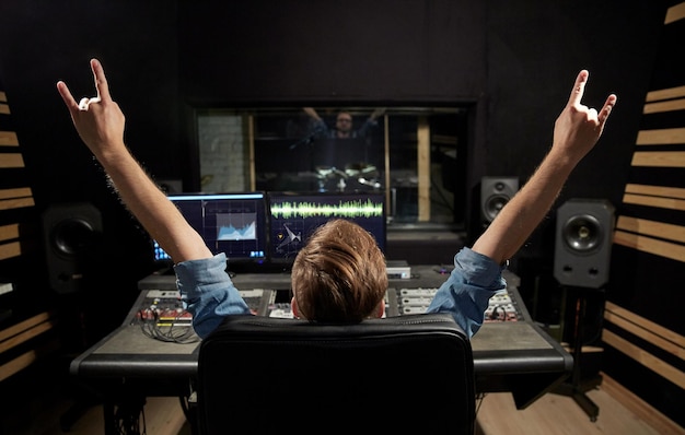 muziek technologie mensen en apparatuur concept gelukkige man bij het mixen console in geluid opname studio tonen rock gebaar