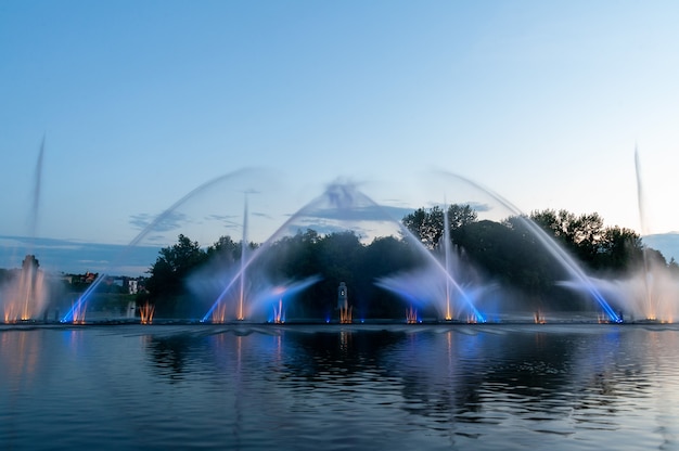 Muzikale fontein met laseranimaties. Nachtelijke laserfonteinshow, aan de Roshen-dijk, de Oekraïense stad Vinnitsa.