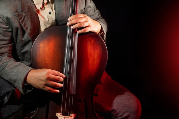 Muzikant die cello speelt Een cellist of cello-speler die optreedt met een zwarte achtergrond