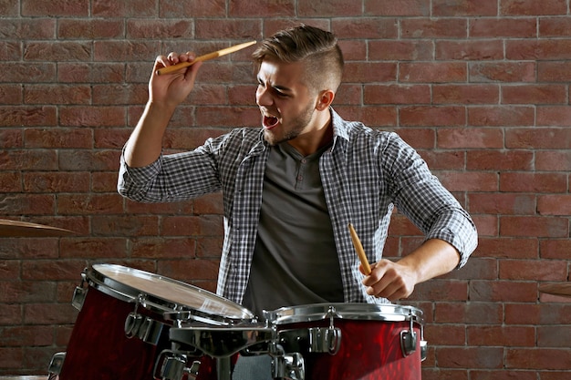 Foto muzikant drummen op bakstenen muur achtergrond