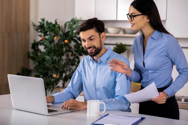 My advice Cheerful female personal assistant helping her boss while standing in the kitchen