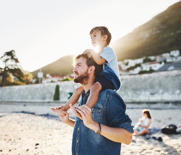 On my Dads shoulders where I get the best view Shot of a young Father and son spending quality time at the beach