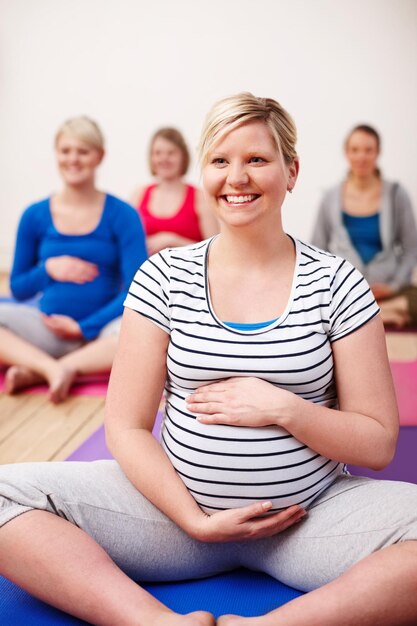 写真 私の焦点は穏やかな出産ですヨガのクラスに足を組んで座って幸せそうに笑っている妊婦のグループ