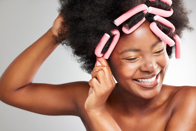 My hair loves this. Shot of a young woman styling her hair against a grey background.