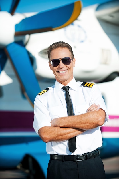 My job is my passion. confident male pilot in uniform keeping arms crossed and smiling