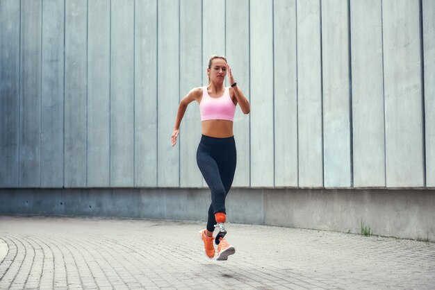 My motivation fulllength of young disabled woman with leg prosthesis in comfortable sports clothing