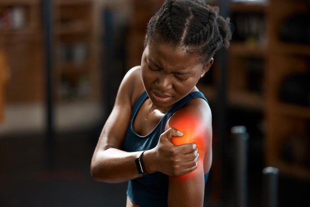 My shoulder is killing me High angle shot of an attractive and athletic young woman holding her shoulder in pain while at the gym