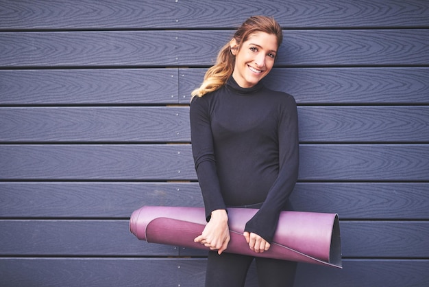Photo my yoga mat is always close by cropped portrait of an attractive young female athlete carrying her yoga mat