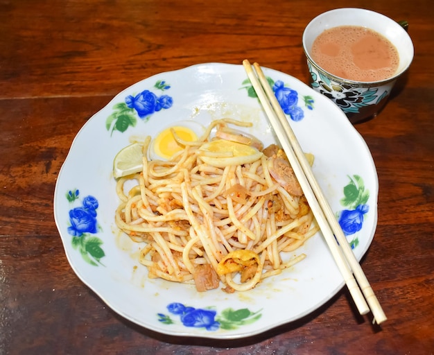 Myanmar thick round noodle salad called Nan Gyi Thohk recipe and a cup of tea. Burmese spaghetti