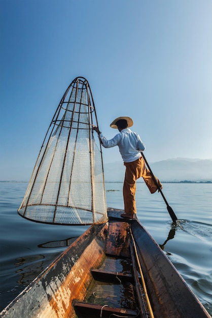 Туристическая достопримечательность Мьянмы Традиционный бирманский рыбак с рыболовной сетью на озере Инле в Мьянме, известный своим характерным видом на греблю на одной ноге с лодки