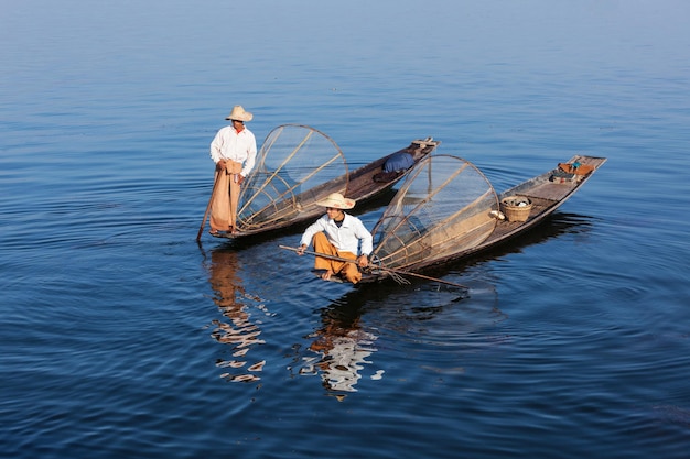 Myanmar travel attraction landmark Traditional Burmese fishermen with fishing net at Inle lake in Myanmar famous for their distinctive one legged rowing style