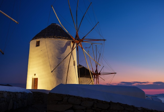 Mykonos grecia mulini a vento tradizionali il simbolo di mykonos durante il tramonto paesaggio durante il tramonto mare e spiaggia foto per viaggi e vacanze